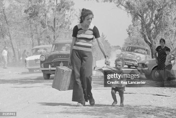 Turkish woman and a small child flee the fighting between Greeks and Turks on Cyprus.