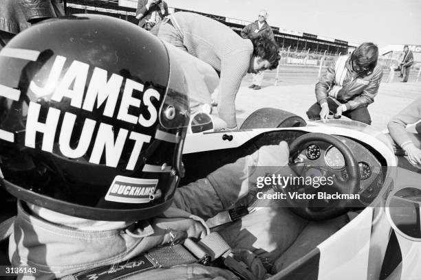 Racing driver James Hunt at the wheel of his car at Silverstone.