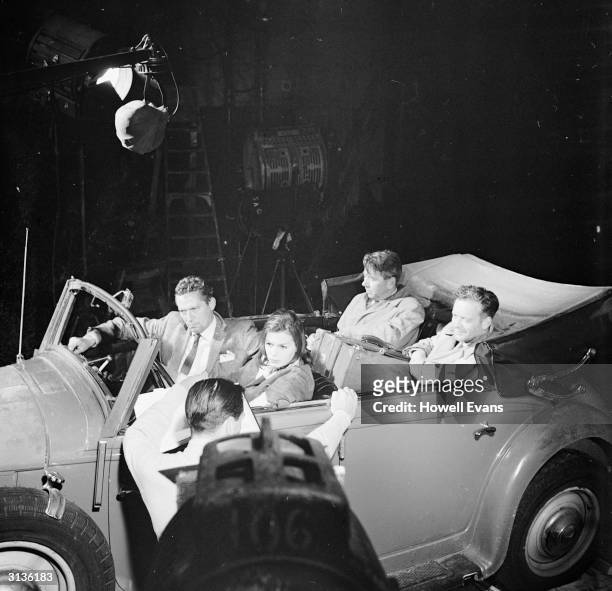 Actors Eva Bartok , Peter Finch , Tony Britton and Alexander Knox in an old Mercedes at Pinewood Studios, filming the Michael McCarthy picture...