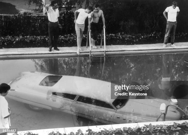 Submerged car which its drunken owner 'parked' in a swimming pool in Beverly Hills, California, believing it to be a parking space. Nobody was...