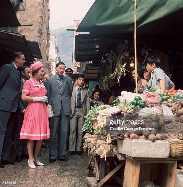 Queen Elizabeth II of Great Britain at a market stall during a royal tour of Hong Kong.