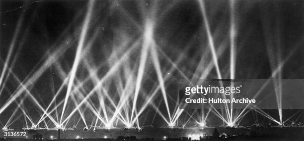 Searchlights fill the sky as the fleet is illuminated during the Coronation review of King George V.