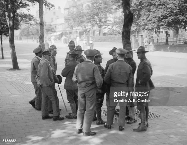 Group of American and British soldiers talking in a street in Southport, Lancashire.