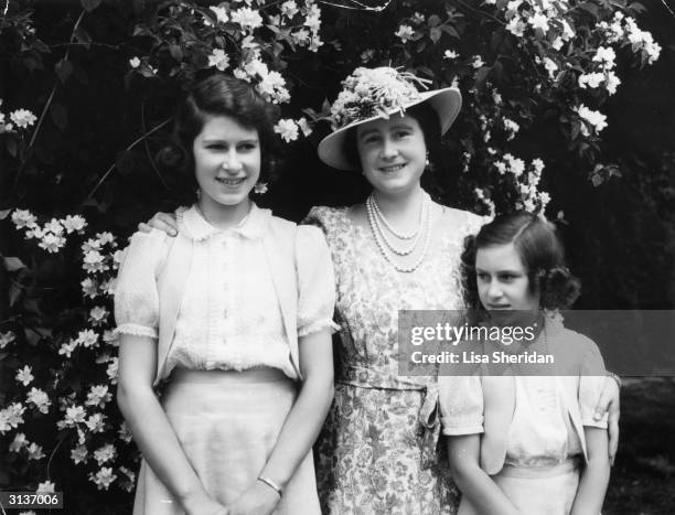 Queen Elizabeth with, on the left, her daughter Princess Elizabeth and on the right Princess Margaret , in the garden at Windsor Castle during WW II.