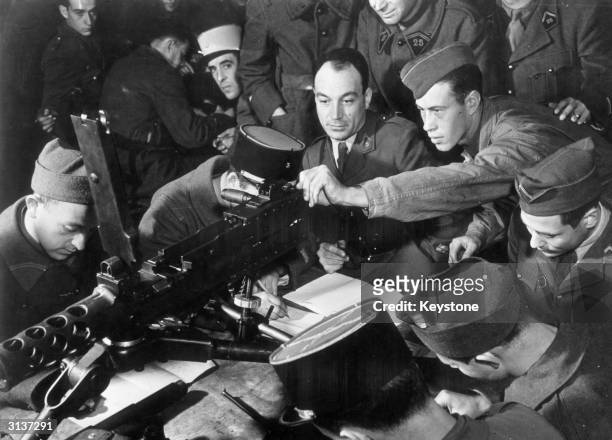 An American soldier in Algiers, north Africa, shows officers and men of the French Army how to operate a .50 calibre machine-gun, part of a shipment...