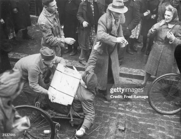 Slave workers fighting over looted food outside a flour mill in Lemgo, a German town captured by soldiers of the US 9th Army.