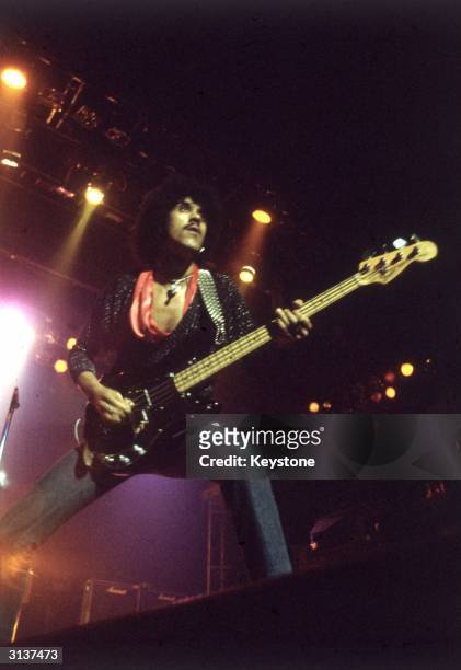 Phil Lynott , singer and bass guitarist with the Irish rock group Thin Lizzy, performs on stage.