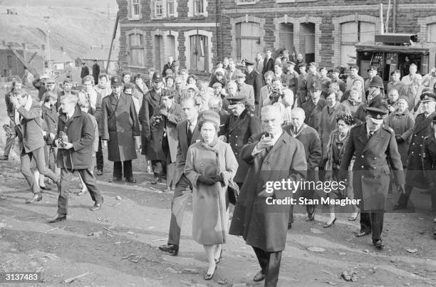 Queen Elizabeth II and Prince Philip visit Aberfan in Wales to comfort the families of the 144 people who died when a coal tip collapsed on the local...