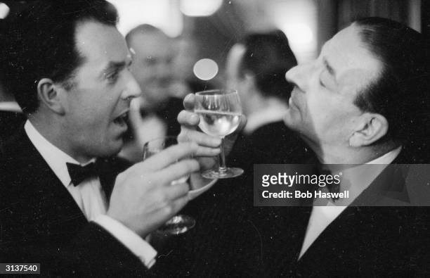 British comedy actor Ronald Shiner drinks a toast with fellow entertainer Brian Rix.