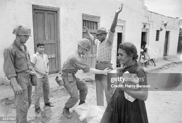 Marines search a man in Dominica during the civil war which led to the island becoming an internally self-governing state in 1967.