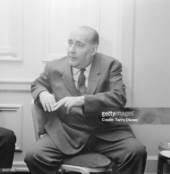 Italian film director Roberto Rossellini attends a press conference at the Cafe Royal.