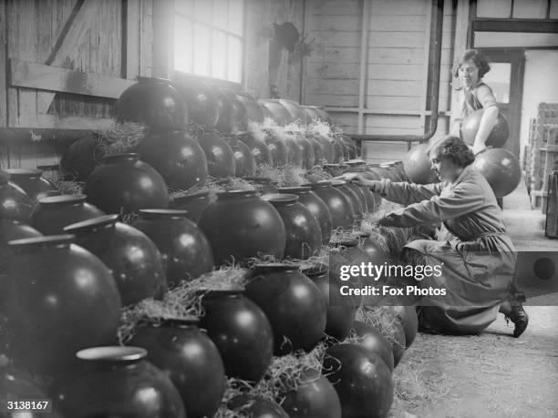 Women workers packing belisha beacon globes in straw at a factory in Morley.