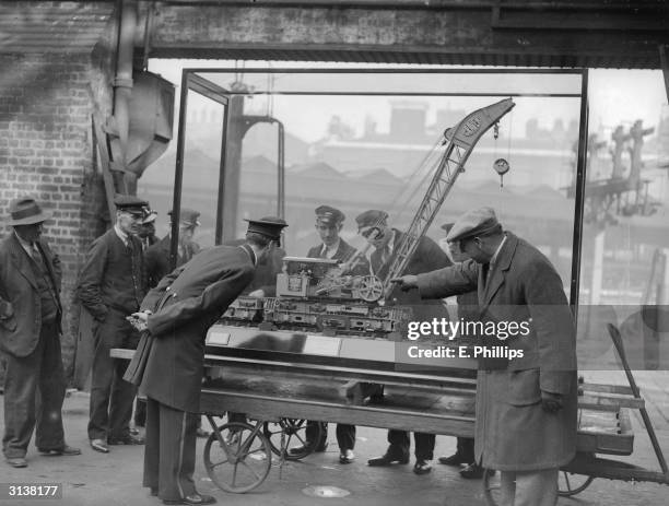 Mr Ward of Northampton explaining his model LMS Rugby steam crane to porters at Euston. On display in the Great Mall, Euston station in London the...