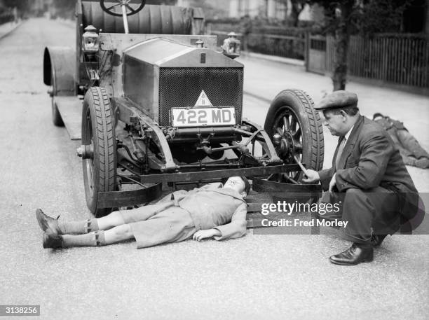 William Lloyd showing off his new invention, cowcatcher bars for cars, with the help of a young assistant. He claims that the bars will prevent...