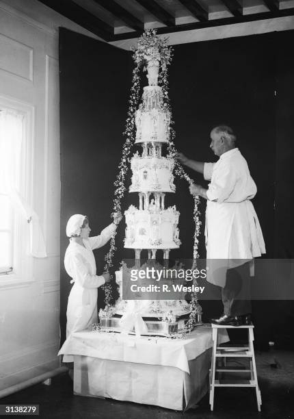 Garlands of flowers are draped over the massive cake being manufactured by Messrs McVitie and Price for the wedding of the Duke of Kent to Princess...