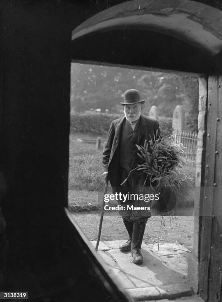 Farmer at Stoke Orchard, near Tewkesbury, bringing in a sheaf of corn to the 12th century church for the annual harvest festival.