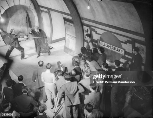 Fighting on a tube station, on the left, comic actor Jack Hulbert and on the right Ralph Richardson in the Gaumont British film, 'Alias Bulldog...