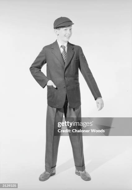 Sixties schoolboy modelling stay-press trousers with turn-ups, a jacket and matching peak cap for sale at John Barkers department store in London.