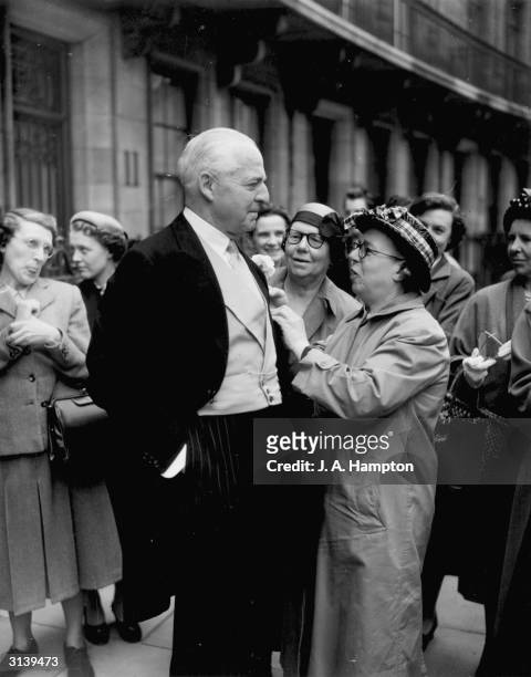 Bystander Miss Lucy Blake fixes the buttohole of Lord Fermoy at the wedding of his daughter, the Hon Frances Roche to Viscount Althorp at Westminster...