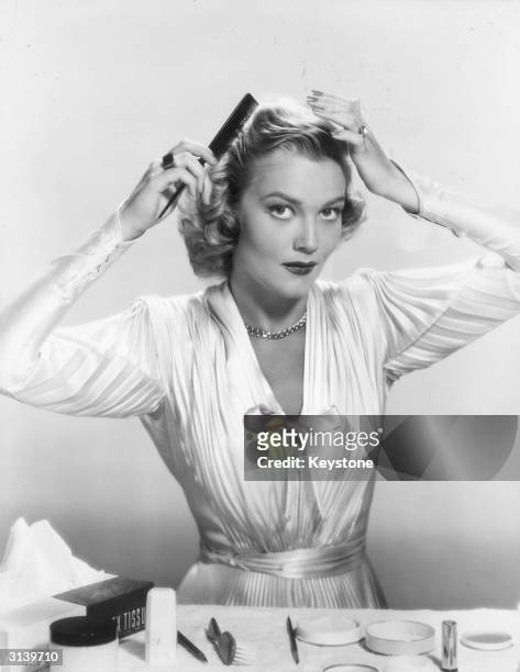 American actress and the wife of wayward actor Errol Flynn, Patrice Wymore combing her hair.