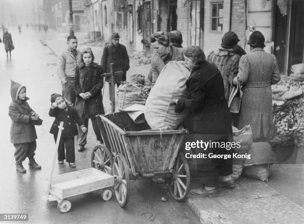 Women buying rationed potatoes for the winter on the kerbside.