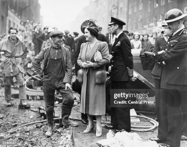 King George VI of Great Britain and Queen Elizabeth talking to a workman in a bomb damaged area of London.
