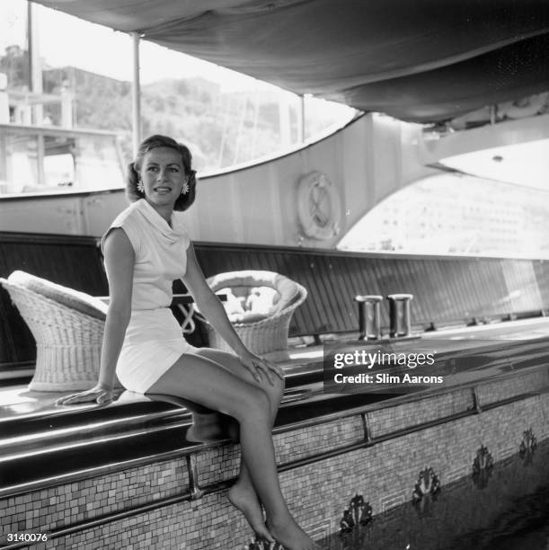 Athina Livanos Onassis the first wife of Greek shipowner Aristotle Onassis relaxing by the swimming pool aboard their yacht, the 'Christina' in Monte...
