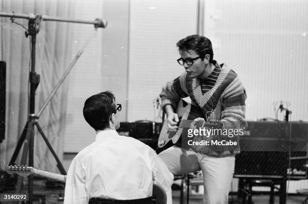 English singer Cliff Richard with Hank B Marvin, of his backing band, The Shadows at the EMI recording studios.