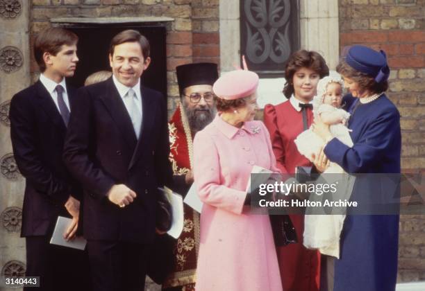 Ex King Constantine of Greece with Queen Anne-Marie and their daughter Princess Theodora at her christening. In the pink outfit is Queen Elizabeth II...