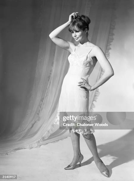 Sixties fashion model wearing a calf-length petticoat trimmed in lace by Slenderella.