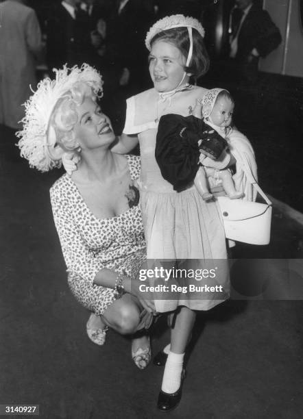 Hollywood sex symbol Jayne Mansfield leaves London's Waterloo Station with her daughter Jayne Marie. She is catching the SS Queen Elizabeth boat...