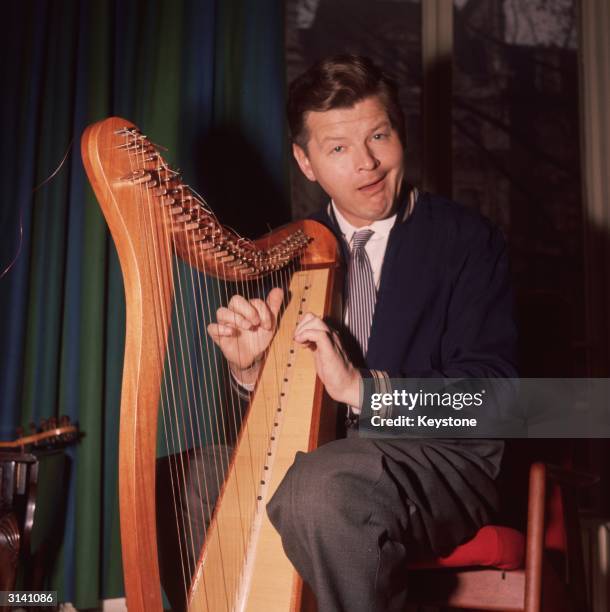 British comedian Benny Hill contrives to play the harp in a lascivious manner.