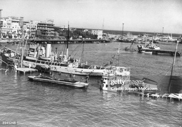 Blockade ships, sunk by the Egyptians during the battle for the Suez Canal lying at the canal entrance in Port Said. Original Publication: Picture...