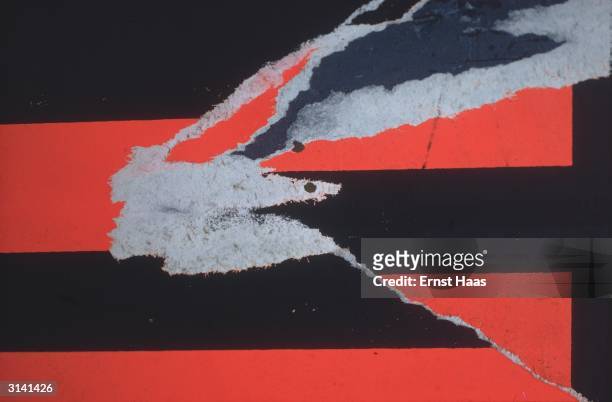 Tear in the vivid red and black pattern of a poster in New York City. Colour Photography book.
