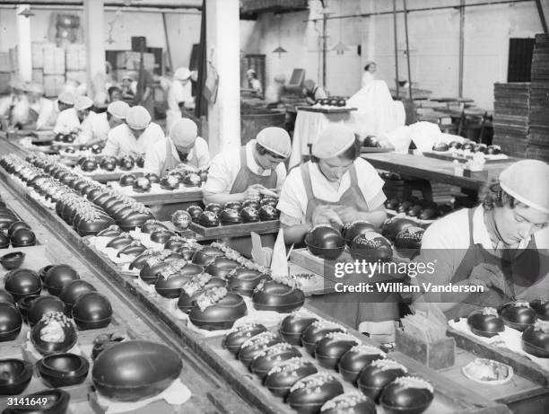 Women icing fancy designs on finished Easter eggs at a Bedford factory.