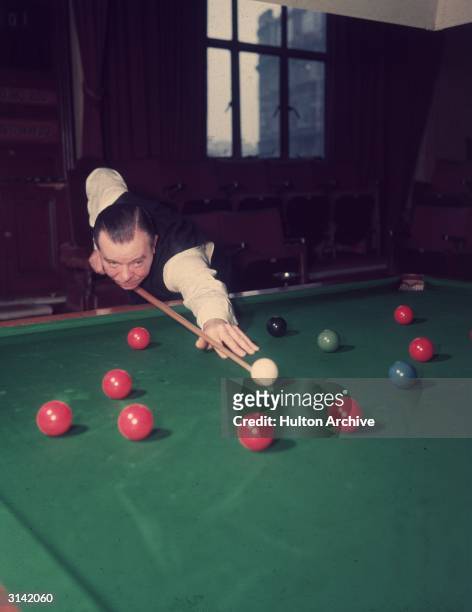 Billiards and snooker champion Joe Davis aiming for a red.