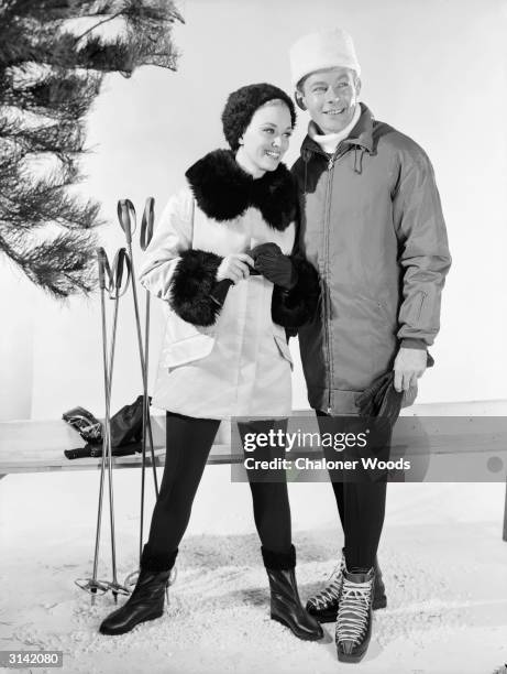 Couple modelling winter coats, hats and gloves.