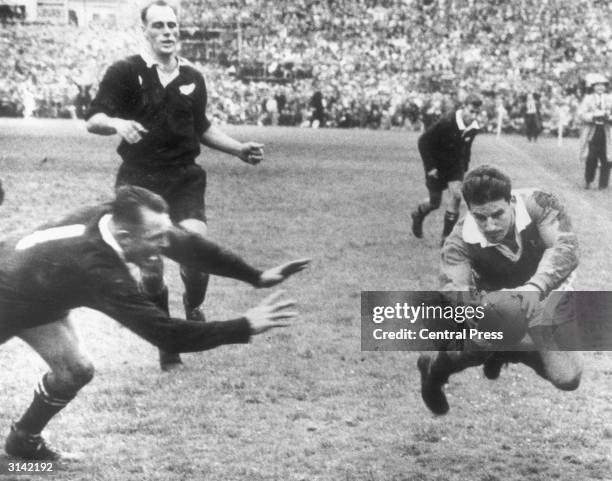 British Lions' fly half Bev Risman scores in the rugby final test match against New Zealand in Auckland. D B Clarke leaves the tackle too late.