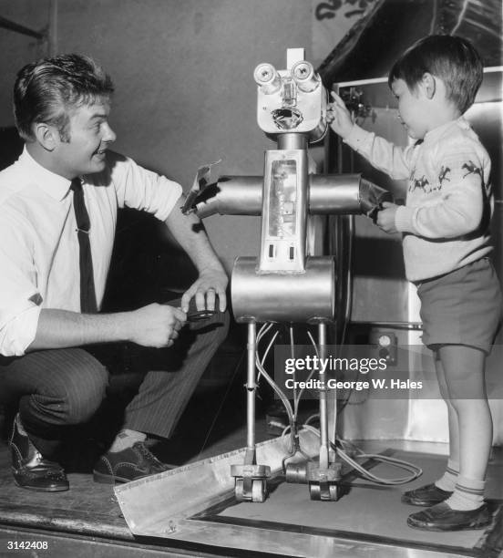 Four year old Stephen Clements inspecting Robby the Robot as its inventor, Bernard Holling looks on. Bernard, a Sunday School teacher, invented the...
