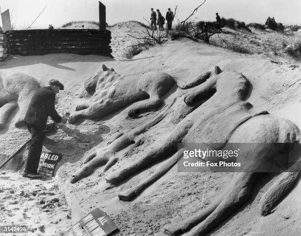 Disabled and unemployed man sculpts animals in the sand to earn some money at Southport in Lancashire.