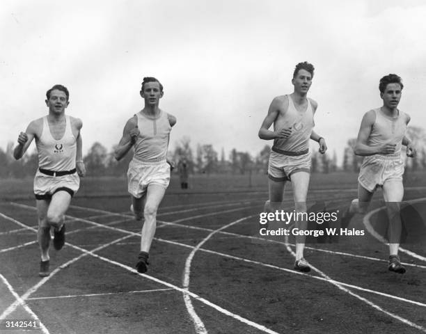 British athletes, Chris Chataway and Roger Bannister during a warm-up lap before an athletics match.