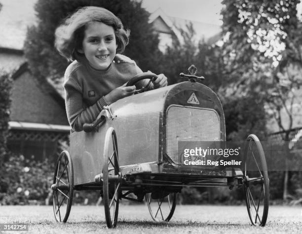 Nine year-old Betty Eyston, daughter of land speed record holder, Captain George Eyston, driving a pedal car during a holiday at Littlehampton.