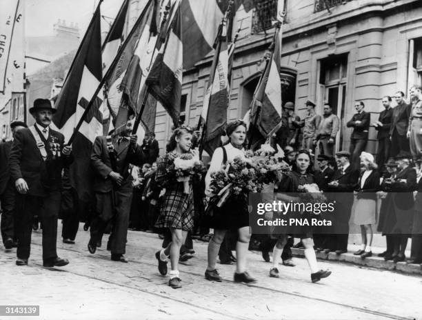 French standards are paraded through the streets during the Bastille Day celebrations in Cherbourg. This is the first such celebration since the...