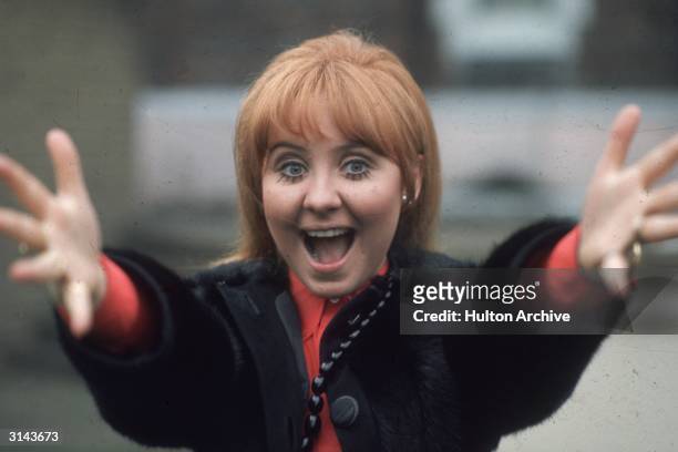Scottish pop start and television presenter, Lulu, reaches out to the camera.