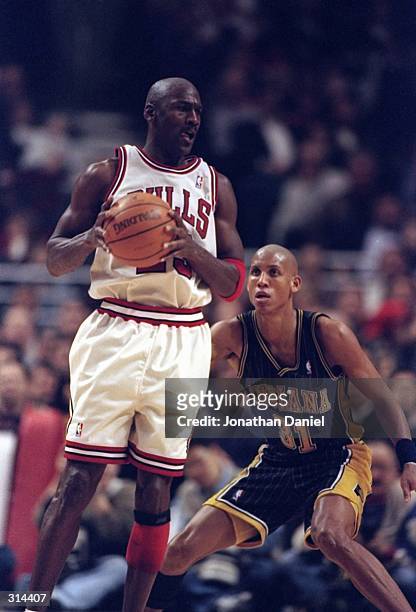 Guard Michael Jordan of the Chicago Bulls moves the ball as guard Reggie Miller of the Indiana Pacers covers him during a game at the United Center...