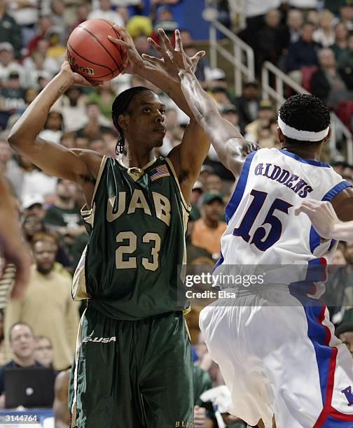 Demario Eddins of the Alabama-Birmingham Blazers takes a shot as J.R. Giddens of the Kansas Jayhawks defends during the third round game of the NCAA...