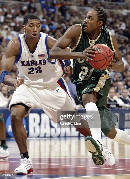 Tony Johnson of the Alabama-Birmingham Blazers drives to the net as Wayne Simien of the Kansas Jayhawks defends during the third round game of the...