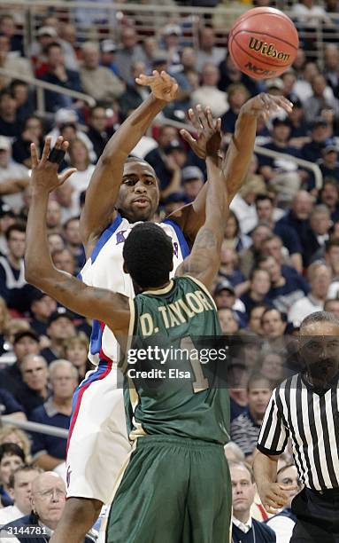 Keith Langford of the Kansas Jayhawks passes the ball over Donell Taylor of the Alabama-Birmingham Blazers during the third round game of the NCAA...