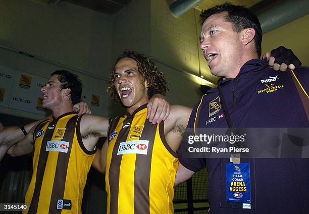 Nathan Lonie, Mark Williams and Peter Schwab of the Hawks sing the club song after the round one AFL match between the Hawthorn Hawks and the...
