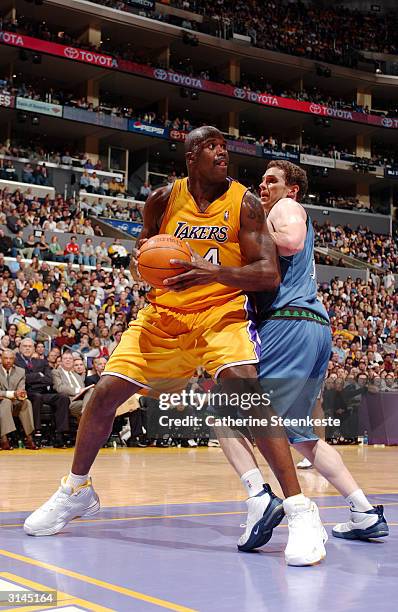 Shaquille O'Neal of the Los Angeles Lakers trying to go to the basket past Mark Madsen of the Minnesota Timberwolves during the second half of action...